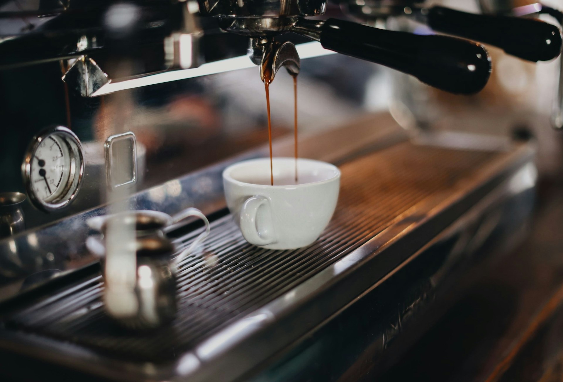 Double espresso being made in a white cup at an Italian coffee machine