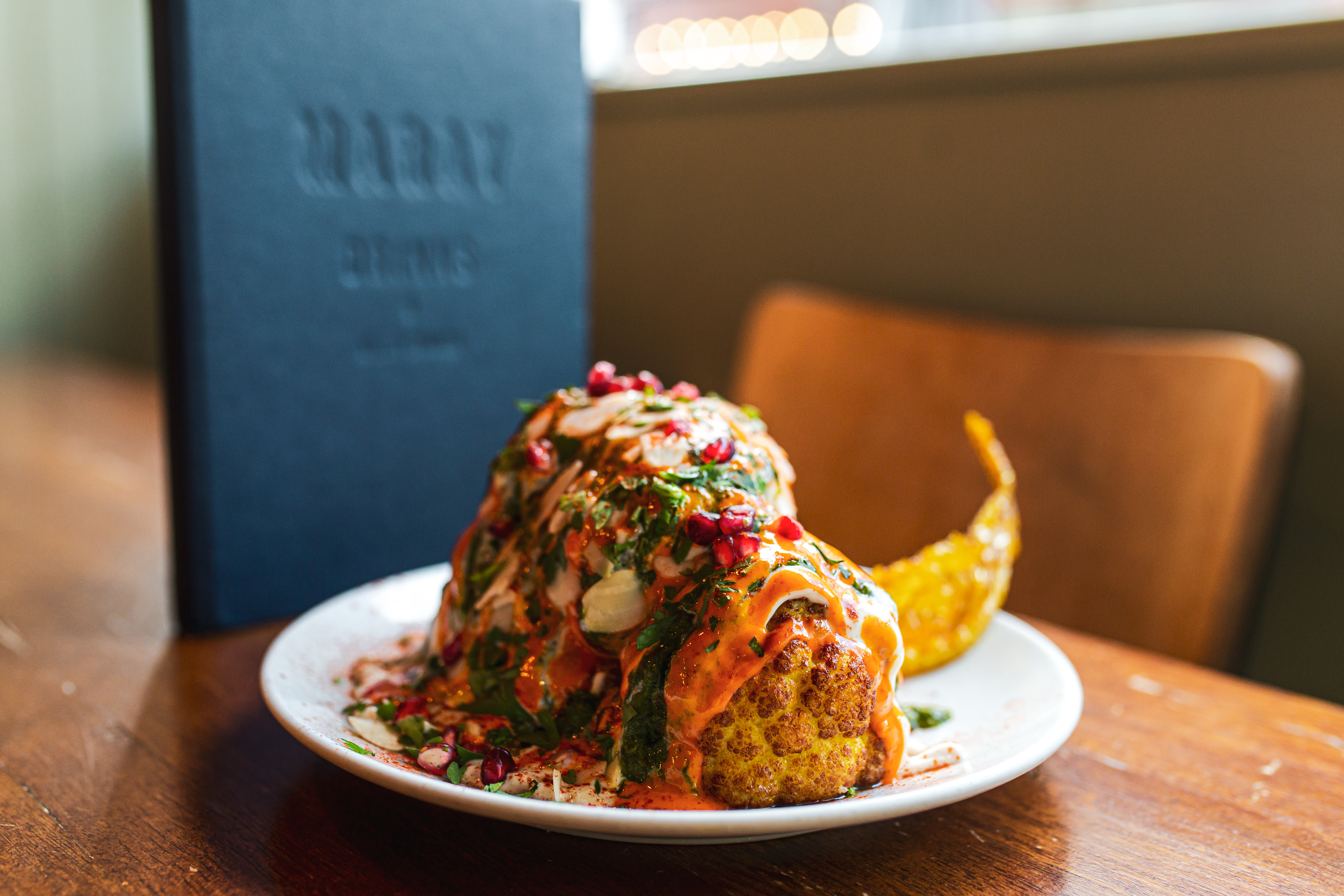 Roasted cauliflower on plate with colourful toppings and sauce