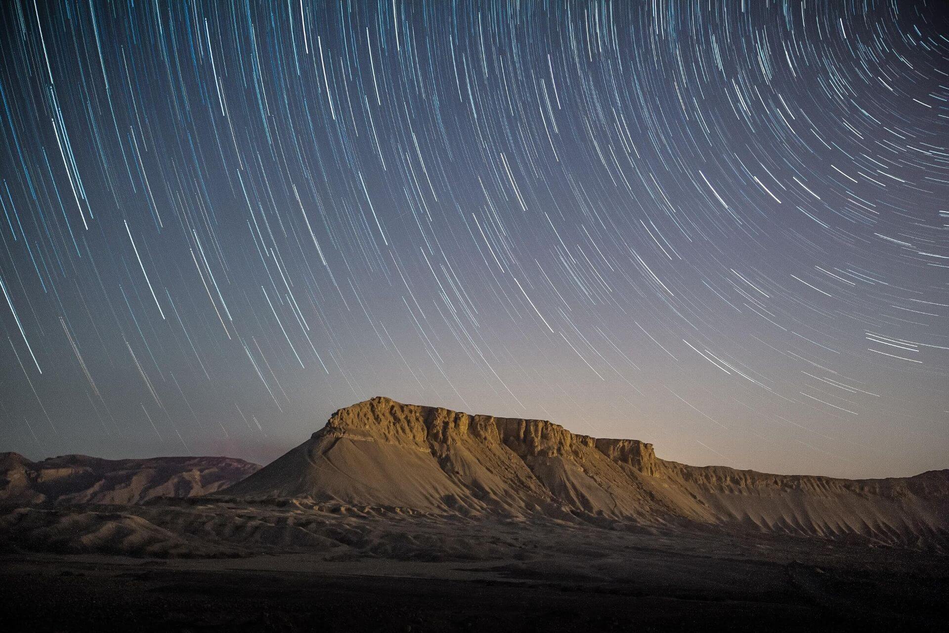 Swirling stars over a desert landscape