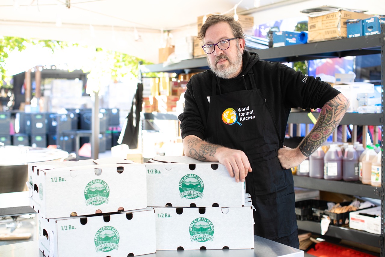 WCK Chef Corps Travis Milton in Asheville, leaning on boxes and looking at camera