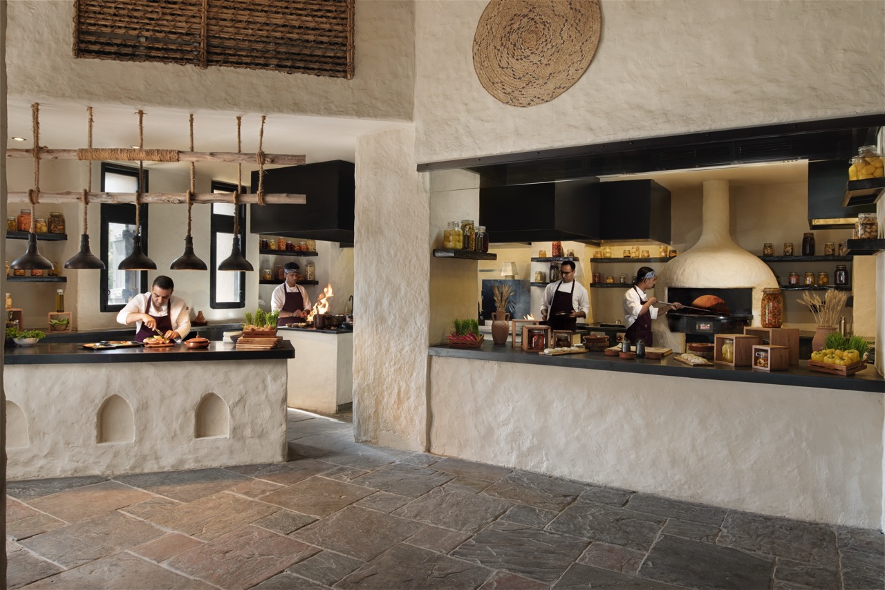 Chefs working in an open kitchen at Six Senses Zighy Bay
