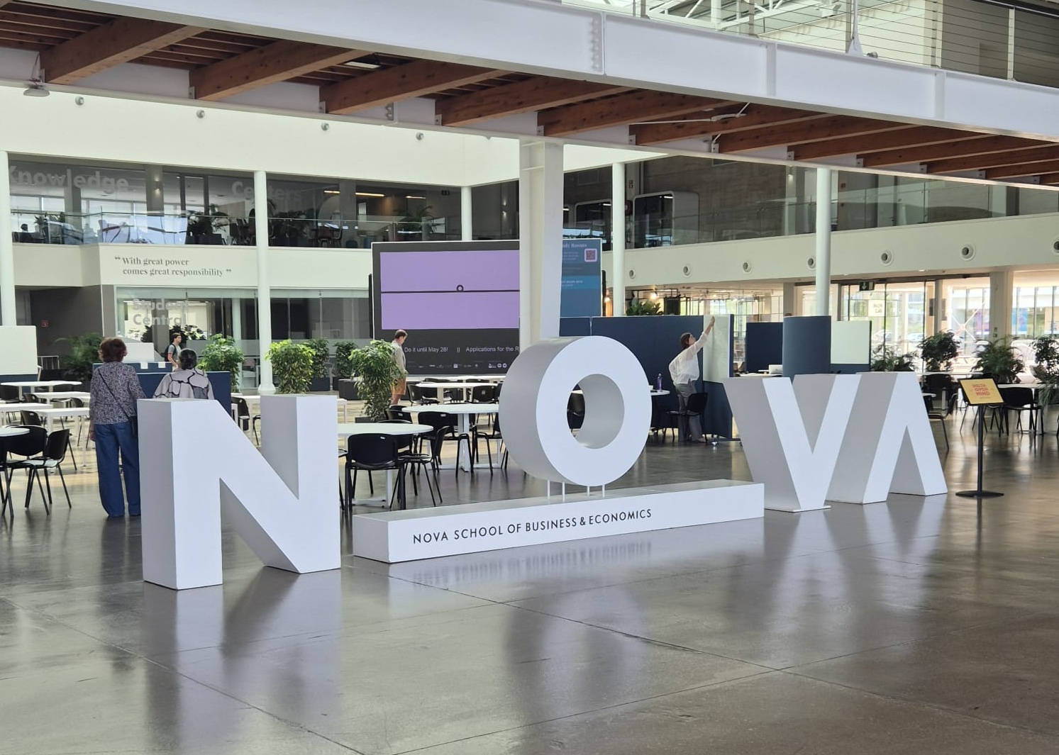 A big 'NOVA' sign in the atrium of Nova School of Business and Economics, Portugal