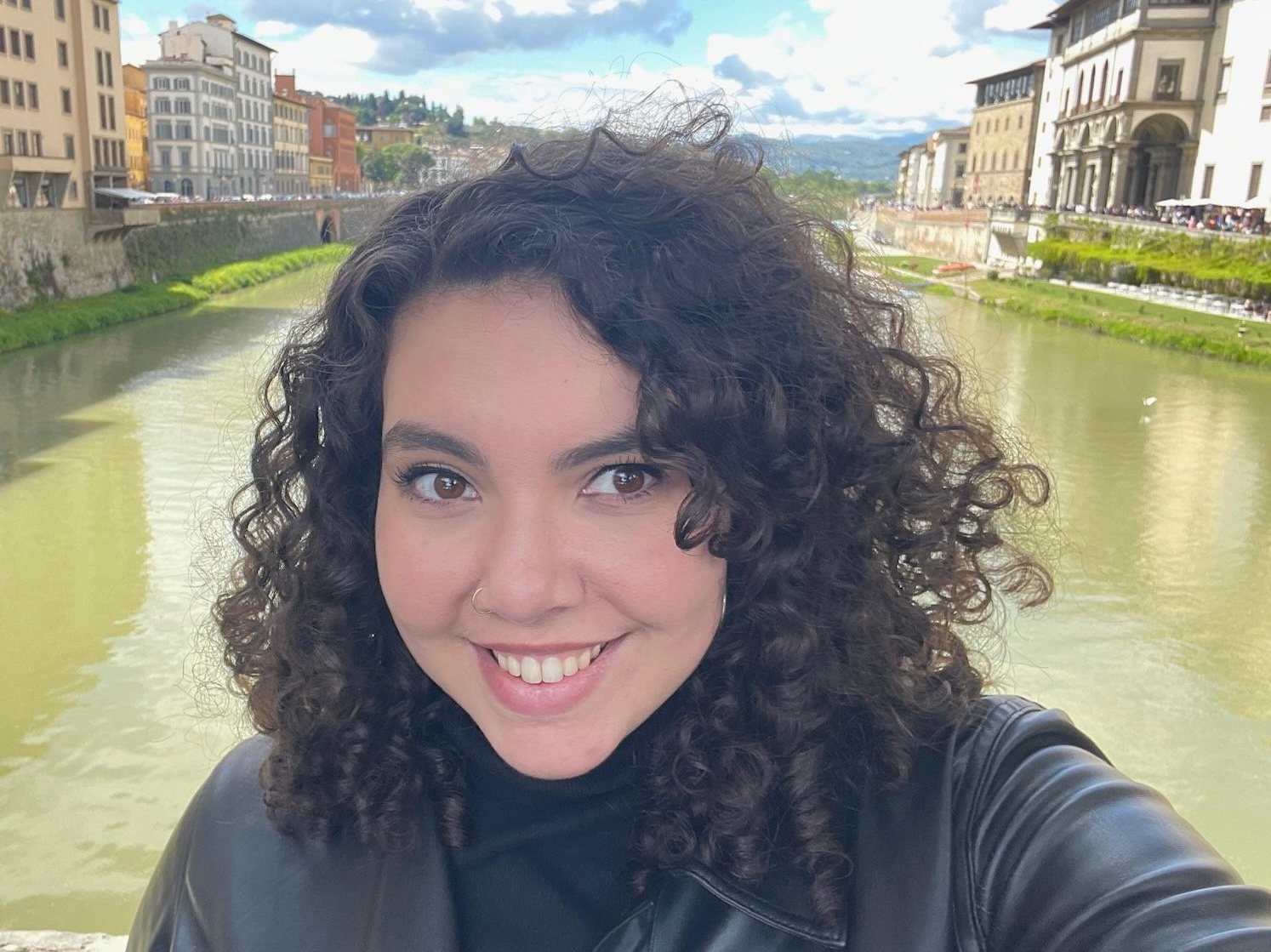 Ayla Gurbuz with a river and buildings in the background