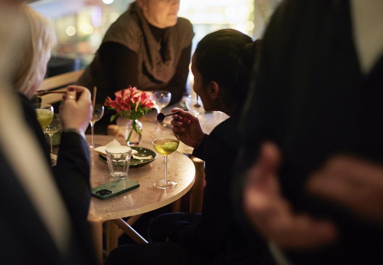 A group of people enjoying cocktails in a softly lit room