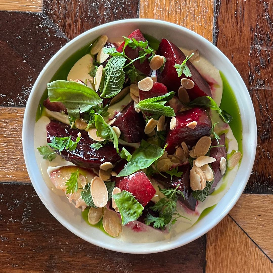 Overhead shot of beautiful vegetarian food on white dish against wooden surface