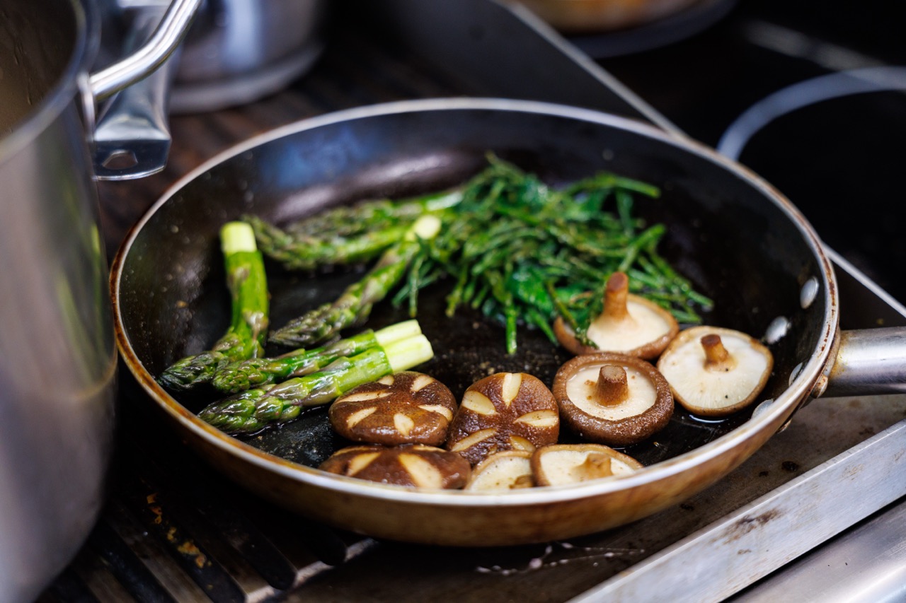 Mushrooms, asparagus and samphire in a frying pan