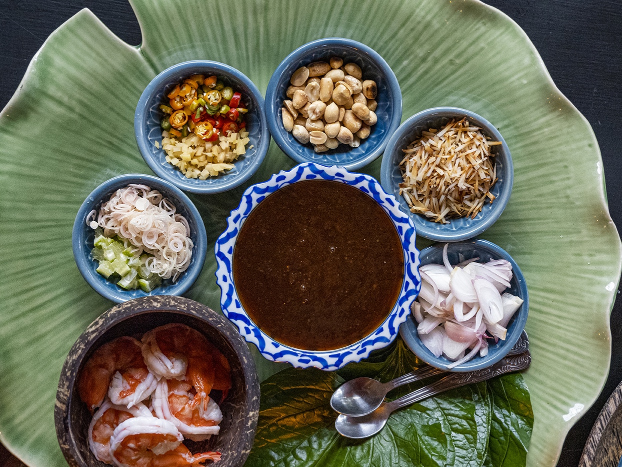 Overhead shot of small bowls of Thai food on green ceramic platter